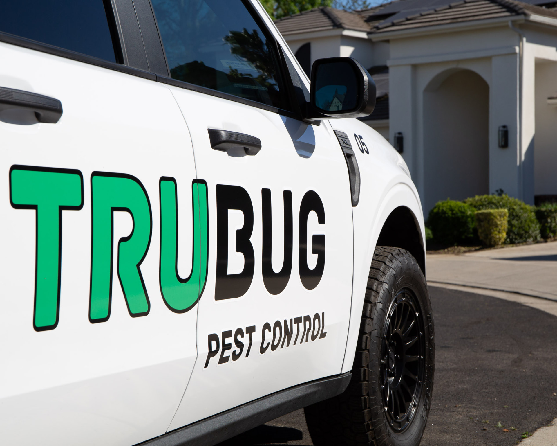 Close-up of the TruBug door graphics on a white service truck