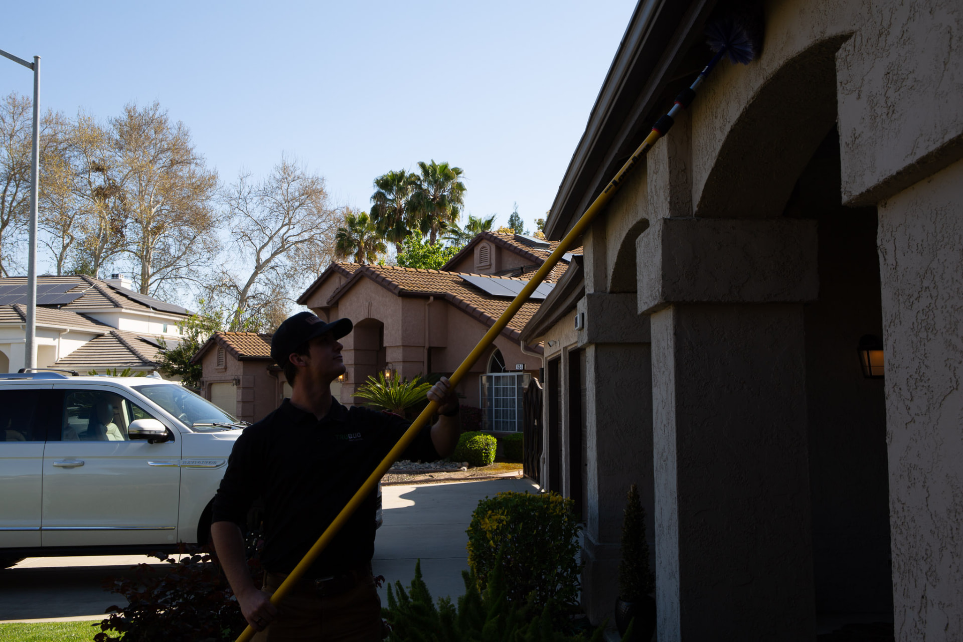 Technician clearing webs from a home's archways